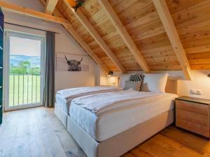 a bedroom with a large bed and a large window at Mountain Chalet An der Mur in Sankt Lorenzen ob Murau