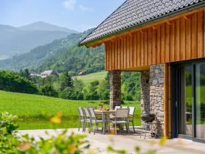 a table and chairs on a patio with mountains in the background at Mountain Chalet An der Mur in Sankt Lorenzen ob Murau