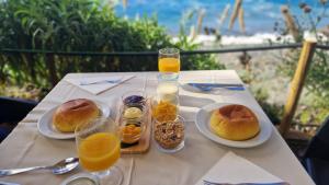 a table with plates of food and glasses of orange juice at Faja dos Padres in Ribeira Brava