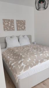 a bedroom with a white bed with a gray comforter at Place2stay Gloggnitz2 in Gloggnitz