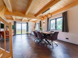 a dining room with a table and chairs and windows at Obermöschach 10A in Obermöschach