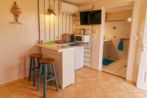 a kitchen with a counter and stools and a microwave at KAZ à STAM in Goyave