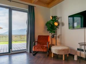 a living room with a chair and a sliding glass door at Obermöschach 10 in Obermöschach