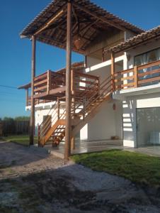 a house with wooden stairs on the side of it at Pousada Cristal - Caraiva in Porto Seguro