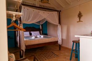 a bedroom with a bed with a canopy at KAZ à STAM in Goyave