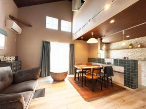 a living room with a table and a kitchen at i GARDEN in Minami Alps
