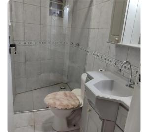 a white bathroom with a toilet and a sink at Lar doce lar, Quarto solteiro Bicama, residência Familiar Compartilhada in Pato Branco