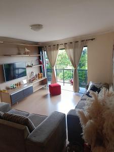 a living room with a couch and a flat screen tv at Lar doce lar, Quarto solteiro Bicama, residência Familiar Compartilhada in Pato Branco