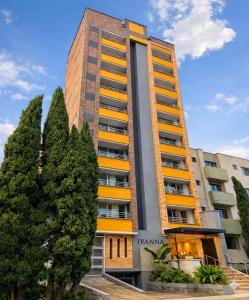 a tall building with trees in front of it at Hotel Ivanna - Laureles in Medellín