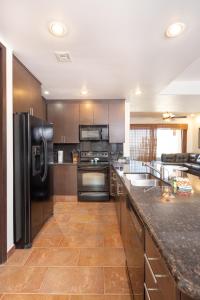 a kitchen with a black refrigerator and a counter at Las Palomas F-1402 Oceanfront Premium Condo - Sleeps 4 in Puerto Peñasco +58 photos