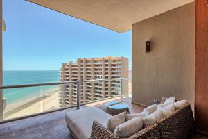 a living room with a balcony with a view of the beach at Las Palomas F-1402 Oceanfront Premium Condo - Sleeps 4 in Puerto Peñasco