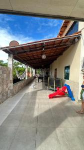 a building with awning and a playground with a slide at Pousada jardim imbassay in Mata de Sao Joao