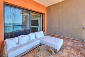 a white couch sitting on a balcony with a window at Las Palomas F-1402 Oceanfront Premium Condo - Sleeps 4 in Puerto Peñasco