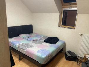 a small bed in a room with a window at Lux 1 in Orléans