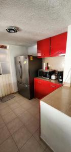 a kitchen with red cabinets and a stainless steel refrigerator at Casa Totalmente Equipada en Acapulco Diamante in Acapulco