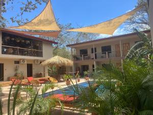 a house with a swimming pool in front of it at Tekana Boutique Hotel Jungle Retreat in Tamarindo