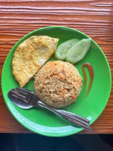 a green plate of food with rice and vegetables at Surya Camp Buahan in Kubupenlokan