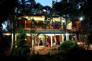 people standing on the balcony of a house at night at KK Heritage in Kannur