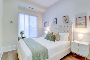 a white bedroom with a large bed and a window at Skyline Penthouse in Toronto +39 photos