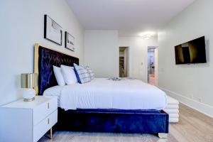 a white bedroom with a large bed and a table at Skyline Penthouse in Toronto