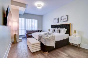 a bedroom with a large bed and a couch at Skyline Penthouse in Toronto