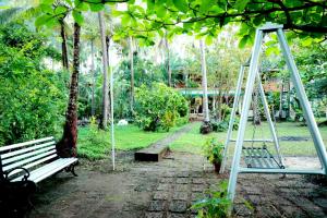 a swing set in a park with a bench at KK Heritage in Kannur
