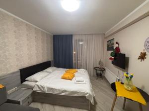 a bedroom with a bed with yellow pillows on it at Orbi Palace Bakuriani in Bakuriani +10 photos