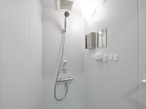 a shower in a bathroom with a shower head at Retrospect Stay Kannai in Yokohama