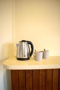 a tea kettle and two cups on a counter at Nr 1 Spot in Paramaribo