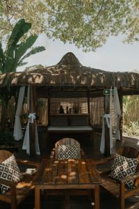 a wooden table and chairs and a gazebo at Pousada Erva Doce in Arraial d'Ajuda