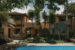 a house with a swimming pool in front of it at Pousada Erva Doce in Arraial d'Ajuda