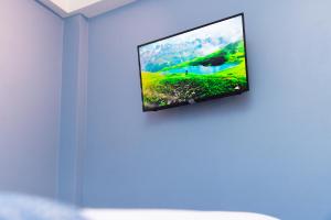a flat screen tv hanging on a wall at Ahra Suites First Floor with ocean view in Kingstown