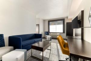 a living room with a blue couch and a table at Holiday Inn Express Hotel & Suites Eugene Downtown - University by IHG in Eugene