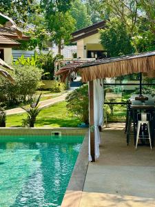 a swimming pool with a gazebo next to a house at Carpe Diem Residence - Adults Only in Thong Sala