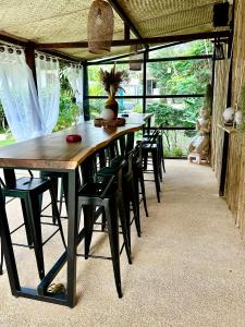 a wooden table and chairs in a room at Carpe Diem Residence - Adults Only in Thong Sala