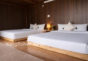 two beds in a room with wooden walls at Kingfisher Nest in Hai Phong +23 photos