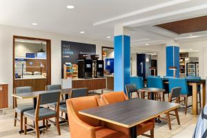 a restaurant with tables and chairs and a bar at Holiday Inn Express Hotel & Suites Eugene Downtown - University by IHG in Eugene
