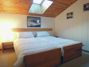 1 dormitorio con 1 cama grande y tragaluz en Attractive Apartment in M ribel near Les 3 Vall es, en Méribel