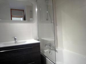 y baño con ducha, lavabo y bañera. en Attractive Apartment in M ribel near Les 3 Vall es, en Méribel