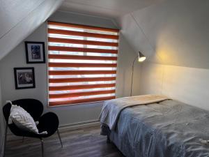 a bedroom with a window with a bed and a chair at Magnolia Mini House Casa A in Puerto Natales