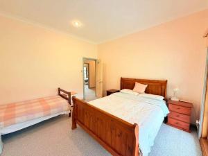 a bedroom with a bed and a dresser and a mirror at Spacious Queen and Single Farmhouse Room in Worragee