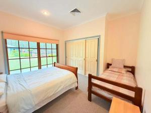 a bedroom with a bed and a bench in it at Spacious Queen and Single Farmhouse Room in Worragee