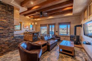 a living room with leather furniture and a stone wall at Cougar Ridge Resort in Torrey