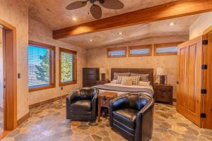 a bedroom with a bed and two leather chairs at Cougar Ridge Resort in Torrey +17 photos