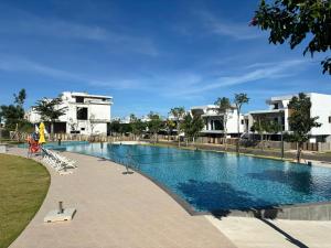 a large swimming pool in a resort with buildings in the background at Aurora Golf Villa in Bình Sum