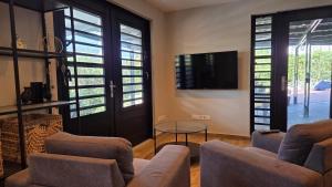 a living room with two couches and a tv at Kahlúa Suites in Grote Berg