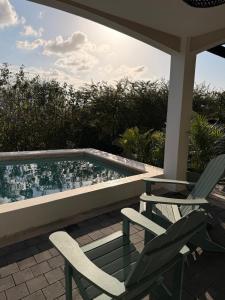 a patio with two chairs and a swimming pool at Kahlúa Suites in Grote Berg
