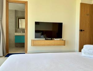 a bedroom with a flat screen tv on a wall at Aurora Golf Villa in Bình Sum