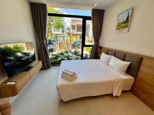 a bedroom with a bed and a large window at Aurora Golf Villa in Bình Sum +42 photos