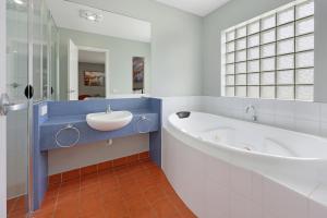 a bathroom with a large tub and a sink at Waves Luxury Suites & Port Central Apartments in Port Campbell